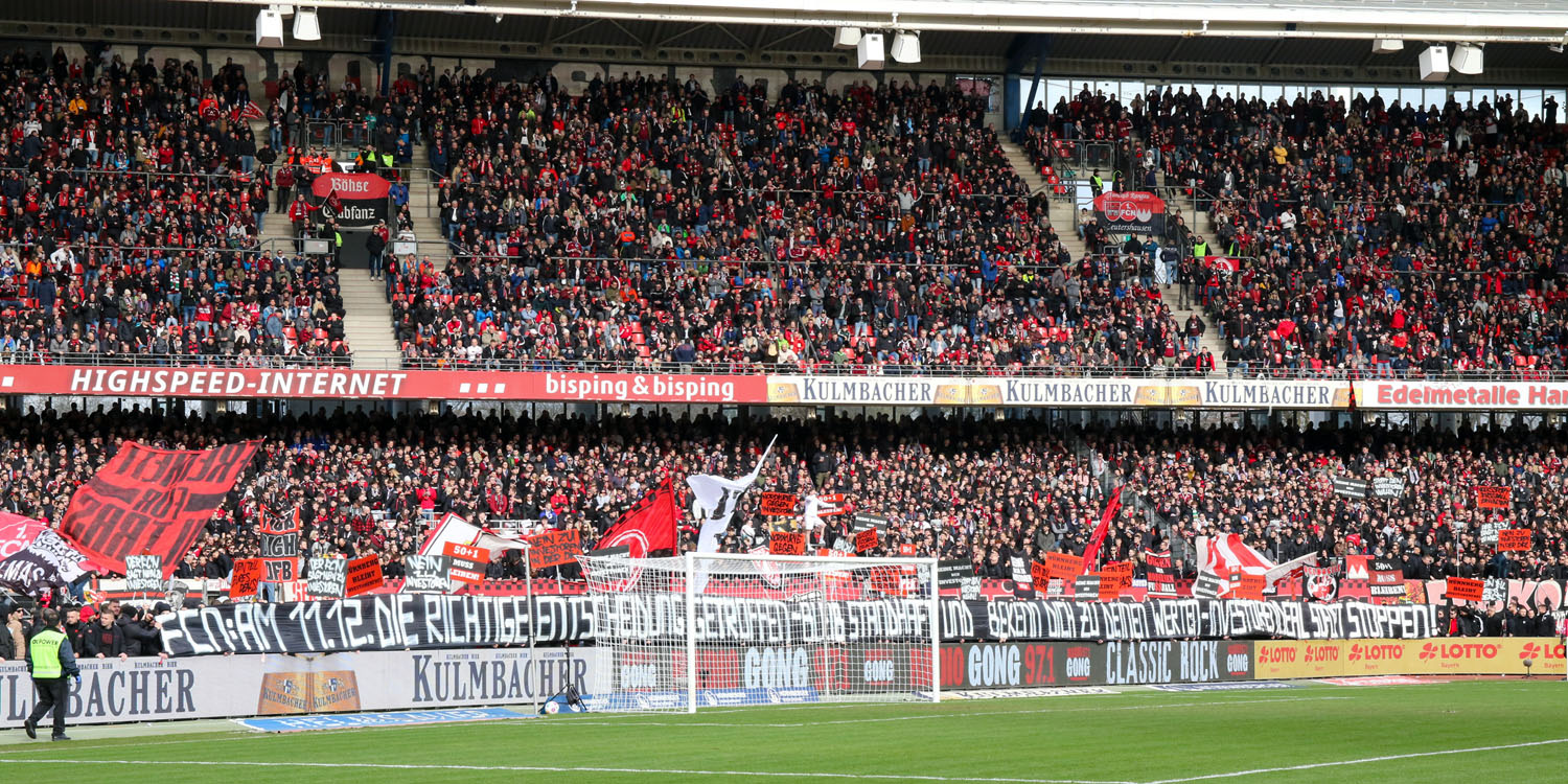 Club-Fans mit Protestplakat am Spielfeldrand