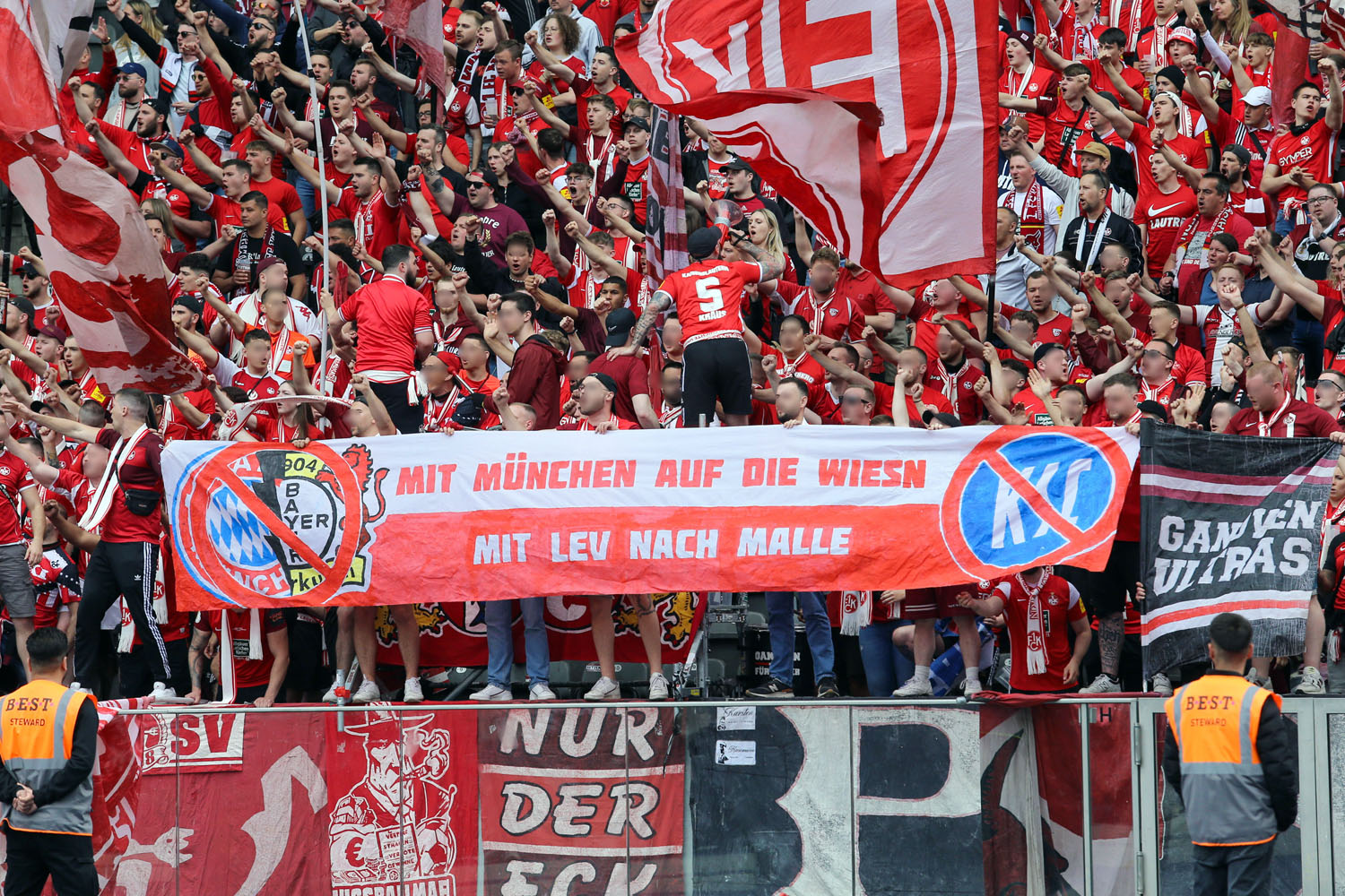 Spruchband im Gästeblock: Mit München auf die Wiesn - Mit Leverkusen nach Malle